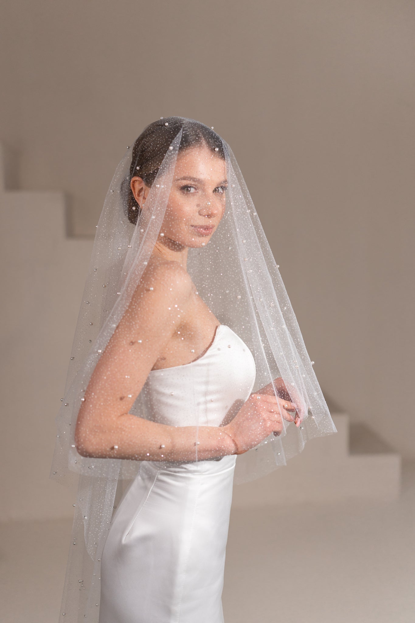 Bride wearing pearl sparkly ivory wedding veil