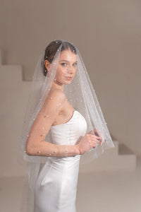 Bride wearing pearl sparkly ivory wedding veil