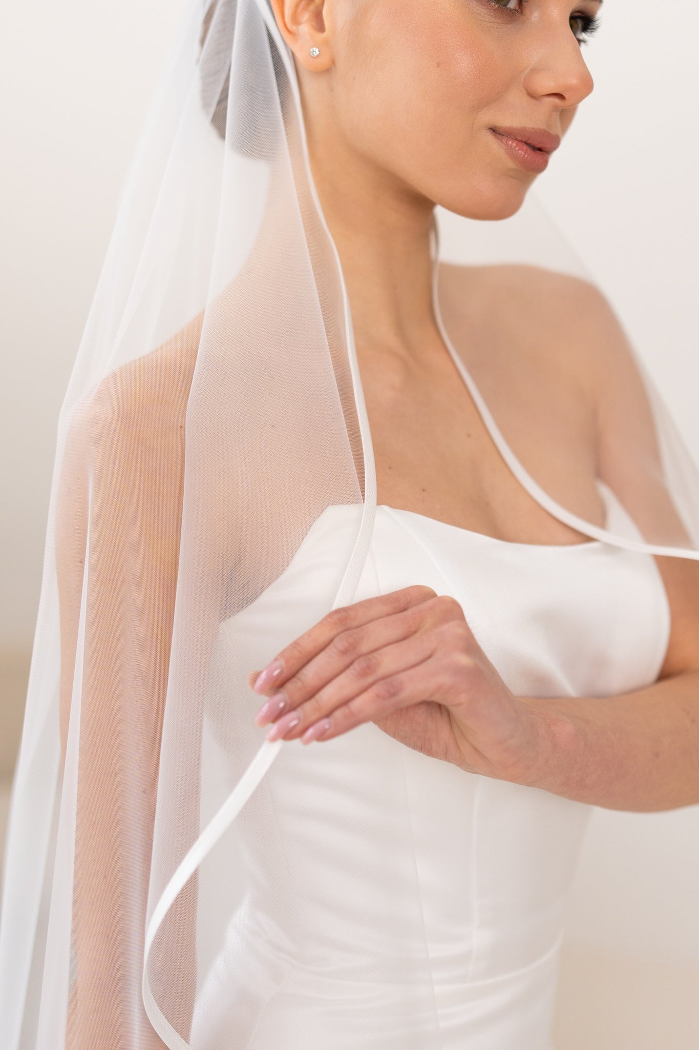 Bride wearing satin ribbon ivory wedding veil