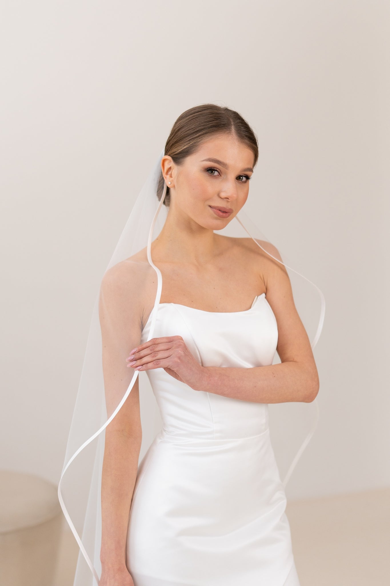 Close-up of satin trim edge on ivory tulle veil